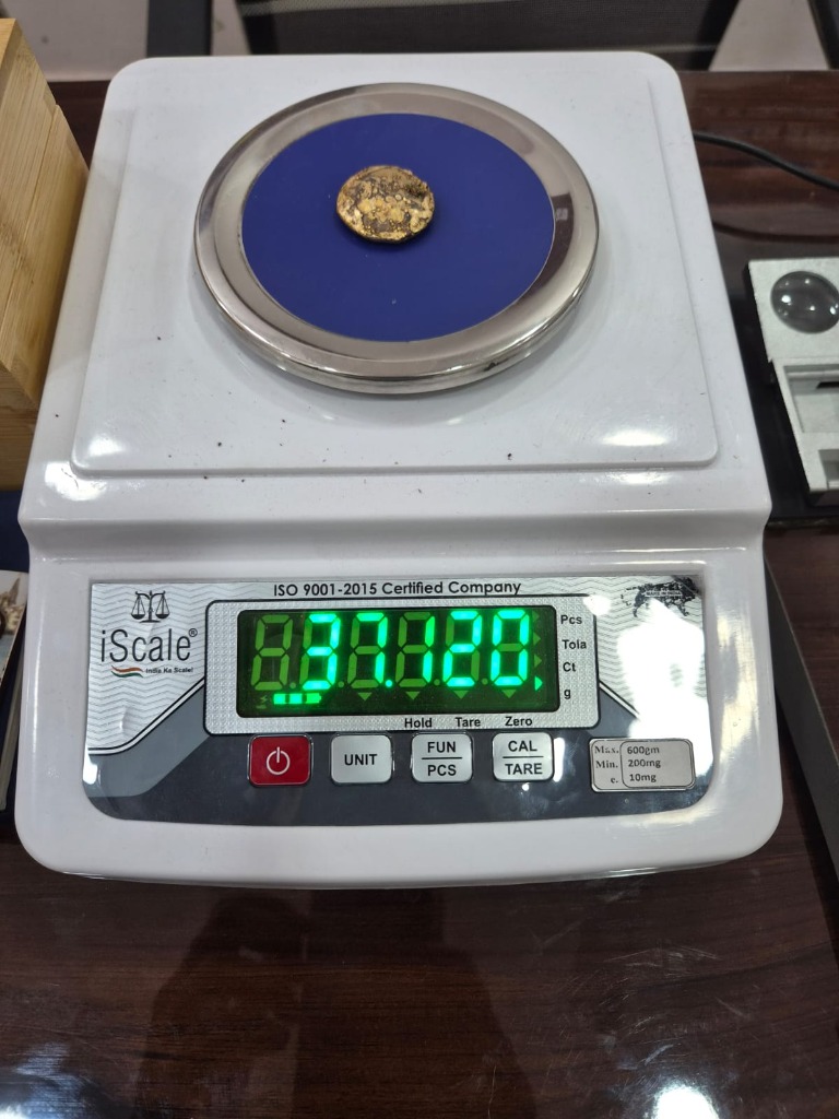 Gold coin on precision weighing scale